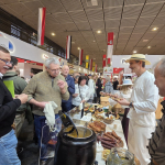 Ludzie odwiedzający targi Grüne Woche w Belinie obok Stoisko Koła Gospodyń Wiejskich  Zakocie „Wygodni Zakociacy”.