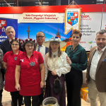 Zastępcy Dyrektora Generalnego KOWR Leszek Iwaniuk i Lucjan Zwolak oraz Dyrektor Departamentu Rozwoju Rynku Witold Wierzbiński pozujący do zdjęcia z przedstawicielami zwycięskiego Koła Gospodyń Wiejskich  Zakocie „Wygodni Zakociacy” na targach Grüne Woche w Belinie.