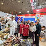 Zastępcy Dyrektora Generalnego KOWR Leszek Iwaniuk i Lucjan Zwolak pozujący do zdjęcia z przedstawicielami zwycięskiego Koła Gospodyń Wiejskich  Zakocie „Wygodni Zakociacy” na targach Grüne Woche w Belinie.